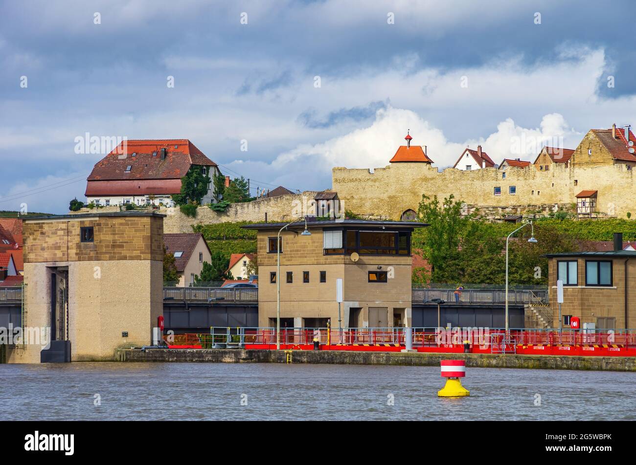 Lauffen am Neckar, Baden-Württemberg, Germania: Diga e serratura nel fiume Neckar con la sagoma della città medievale mura e la città vecchia. Foto Stock