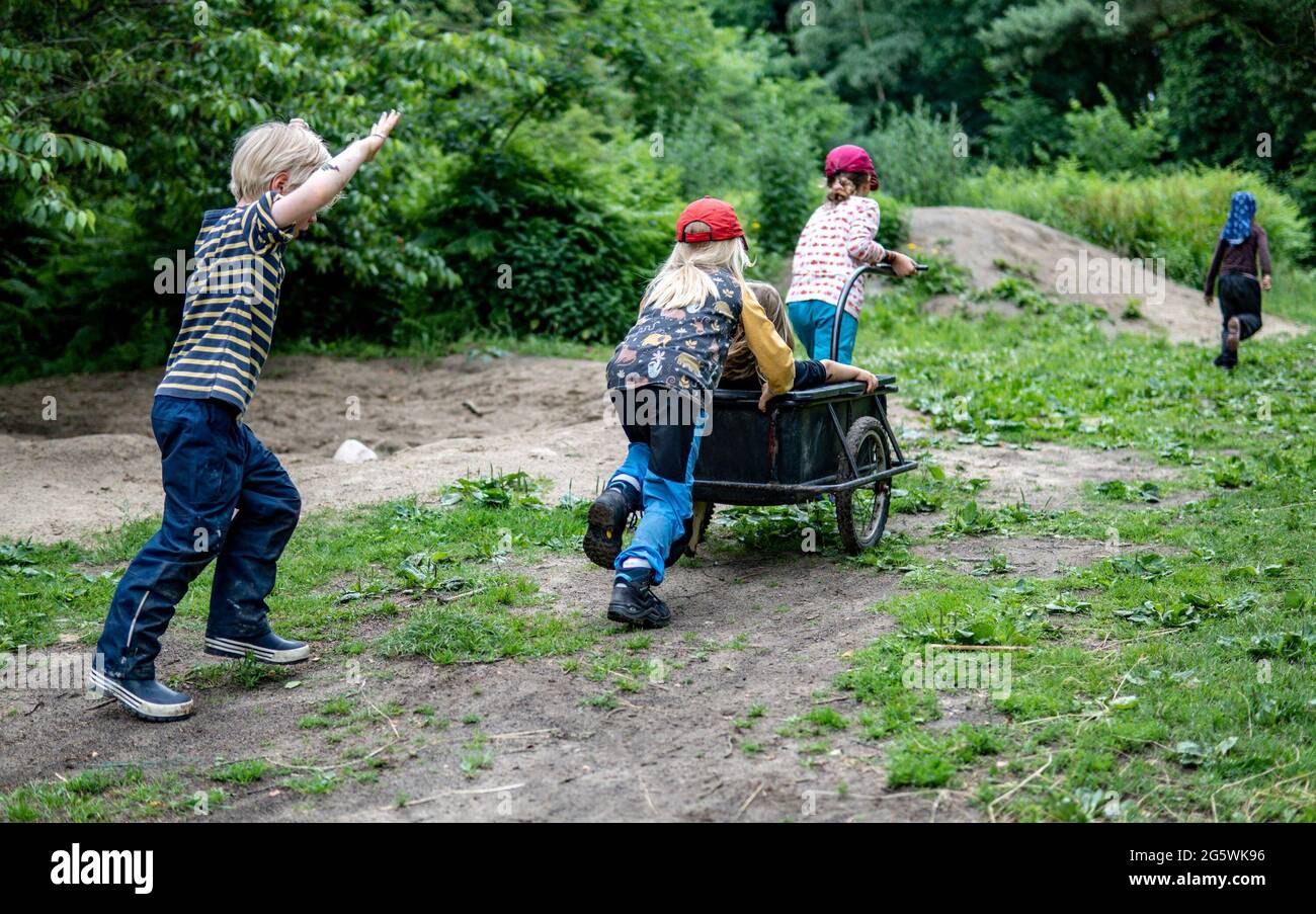 Preetz, Germania. 30 giugno 2021. I bambini del centro di assistenza Wühlmäuse giocano con un rimorchio nella foresta. Credit: Axel Heimken/dpa/Alamy Live News Foto Stock