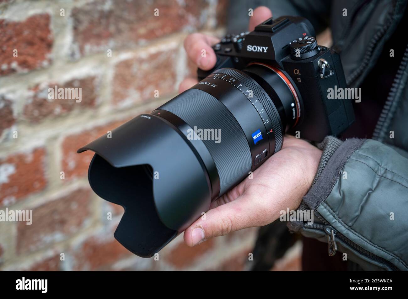 Primo piano di un fotografo maschile che possiede una fotocamera Sony Alpha 9 mirrorless Foto Stock