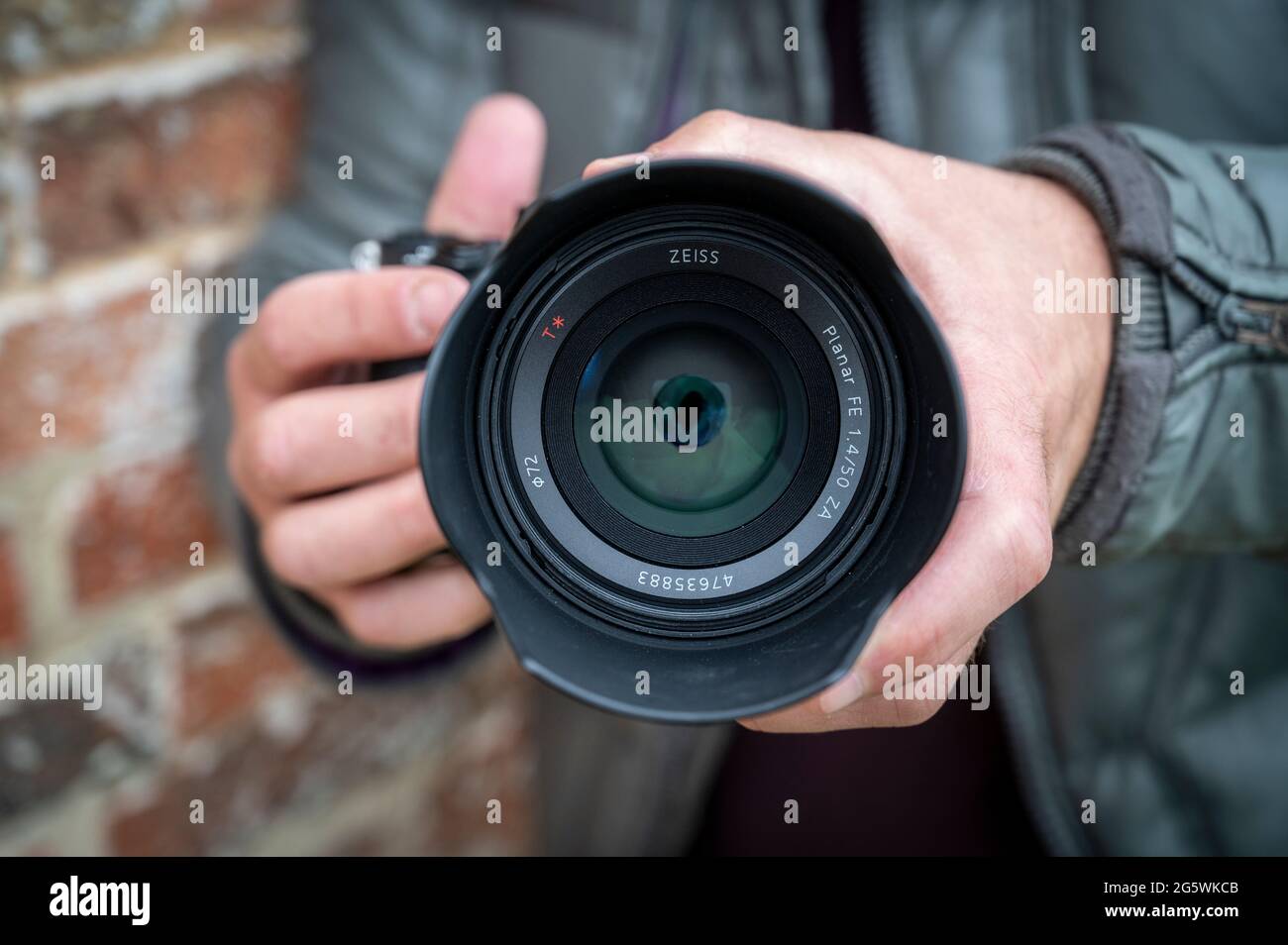 Primo piano di un fotografo maschile che possiede una fotocamera Sony Alpha 9 mirrorless Foto Stock