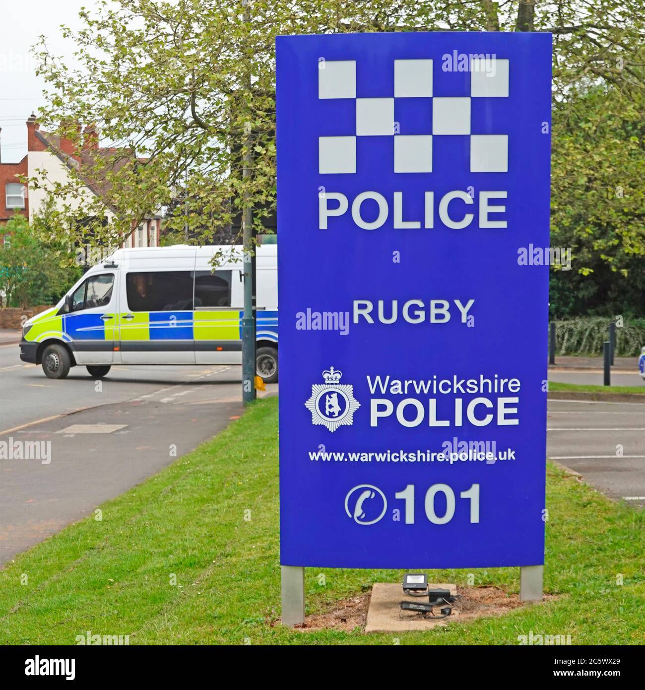 Forze di polizia della contea di Warwickshire constabulary personale vettore veicolo che esce dal centro città di Rugby stazione di polizia edificio segno blu Inghilterra UK Foto Stock