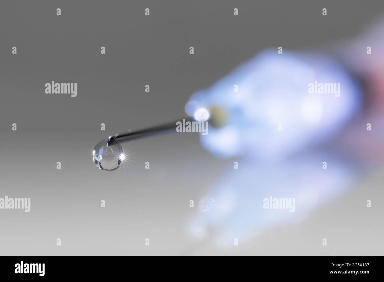 Primo piano della gocciolina sulla punta dell'ago di una siringa. Sanità, industria farmaceutica, abuso di droghe e concetti di vaccinazione Foto Stock