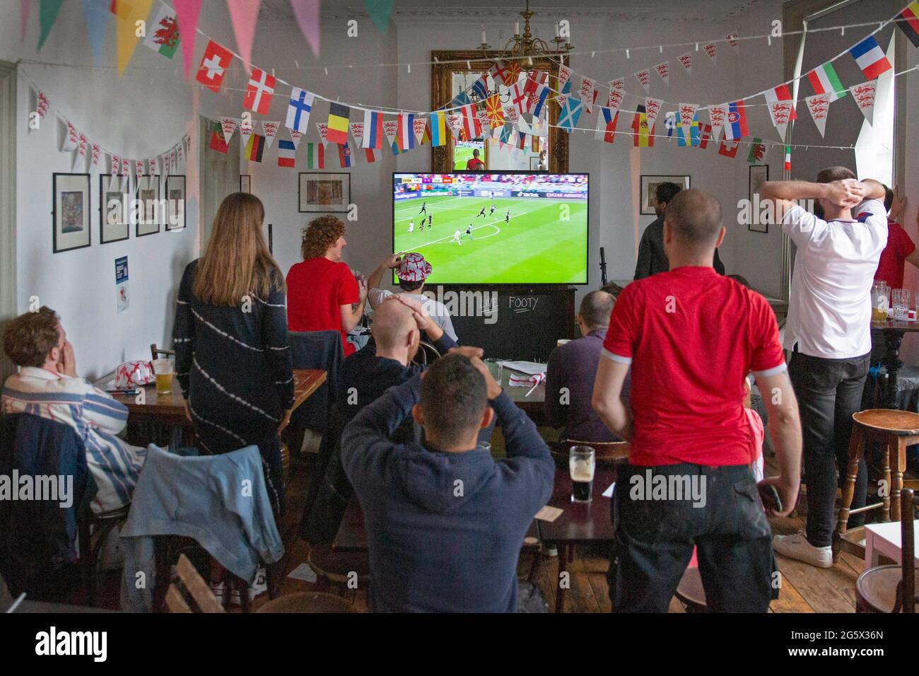 Gli appassionati dell'Inghilterra festeggiano battendo la Germania nel pub Prince George di East London durante il torneo di calcio Euro 2021 Foto Stock