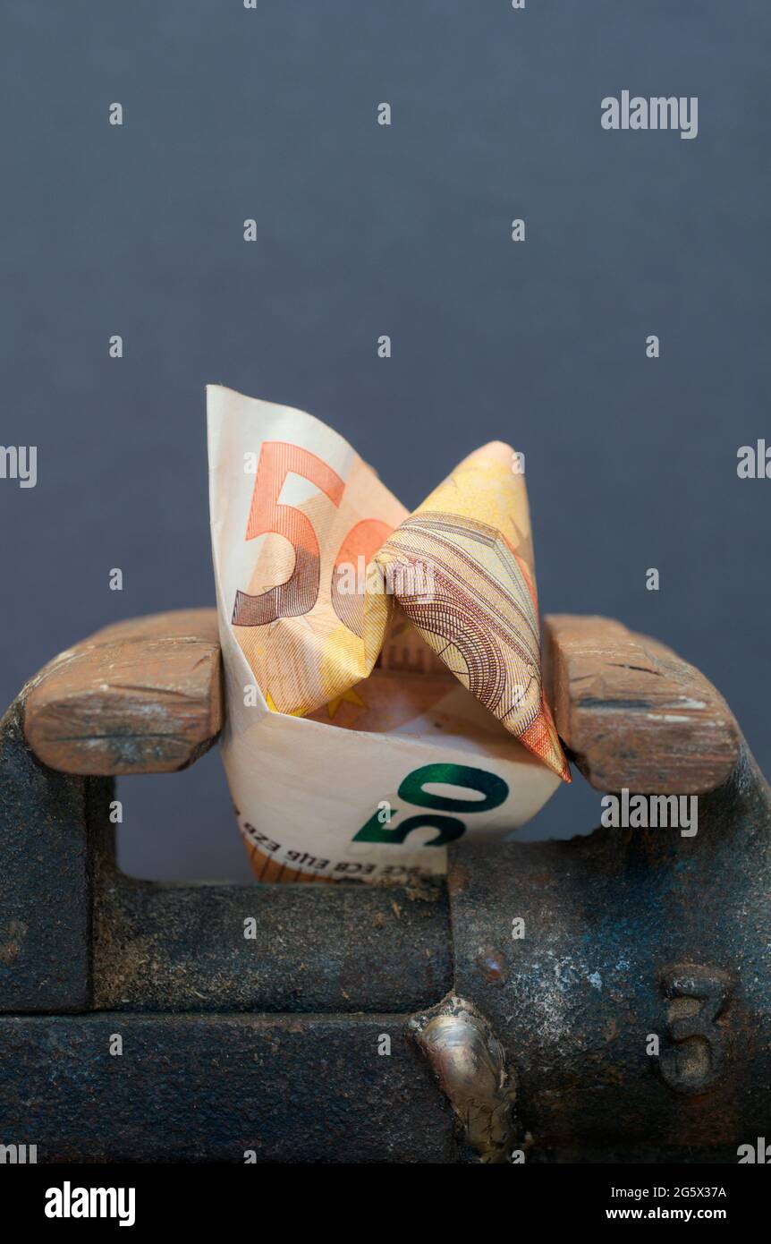 banconote in euro schiacciate tra le mascelle di un vizio Foto Stock