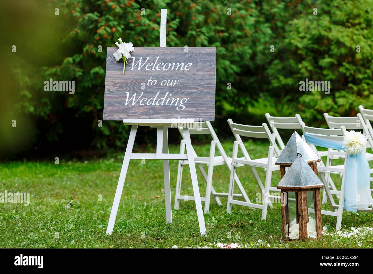 Decorazioni per cerimonie nuziali: Arco, sedie, puntatore e un sacco di fiori in stile bianco e blu, su uno sfondo di verde Foto Stock