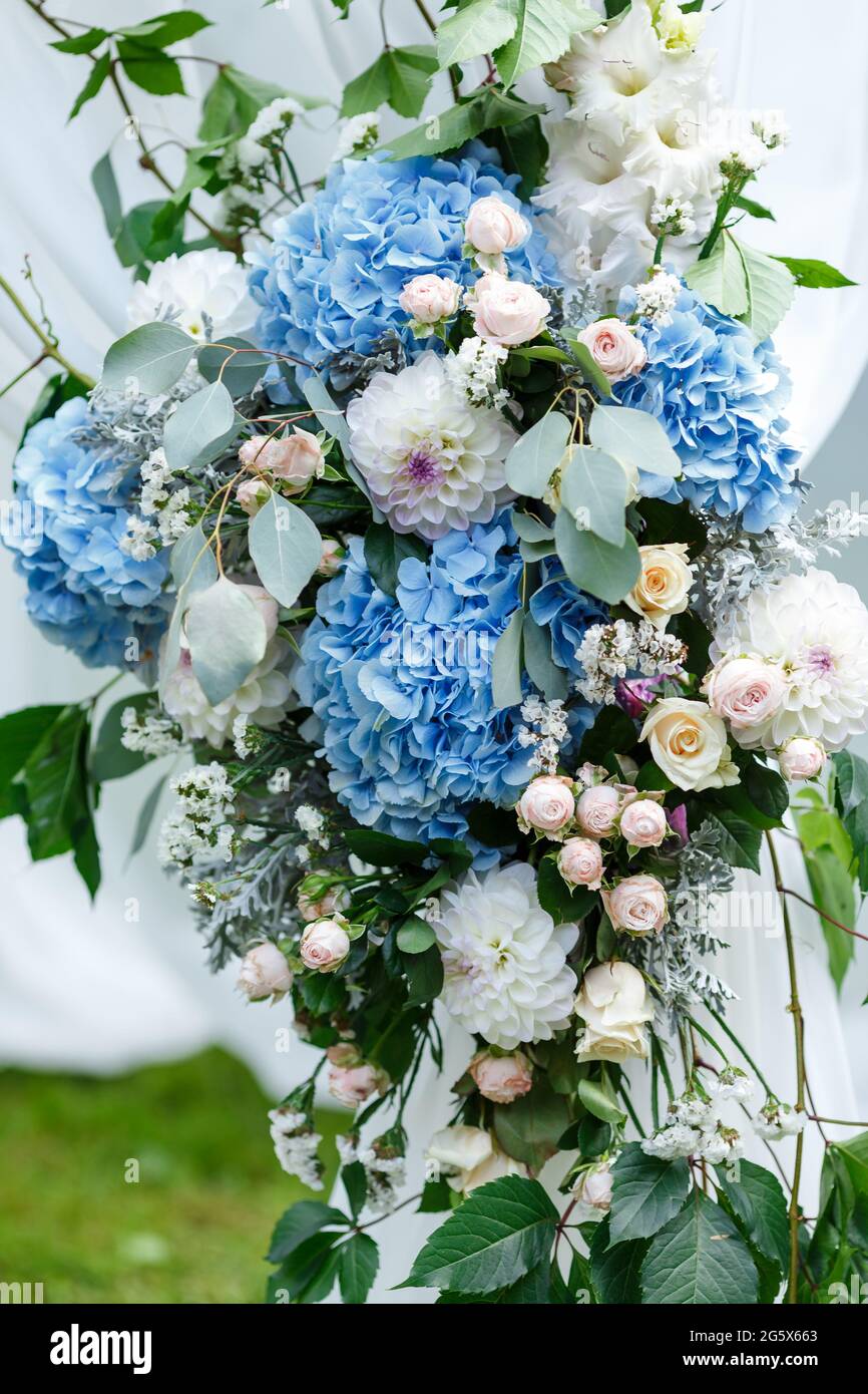 Decorazioni per cerimonie nuziali: Decorazioni ravvicinate dell'arco, decorate con crysantemi, rose, idrangee e vegetazione. Un sacco di fiori in bianco e blu Foto Stock