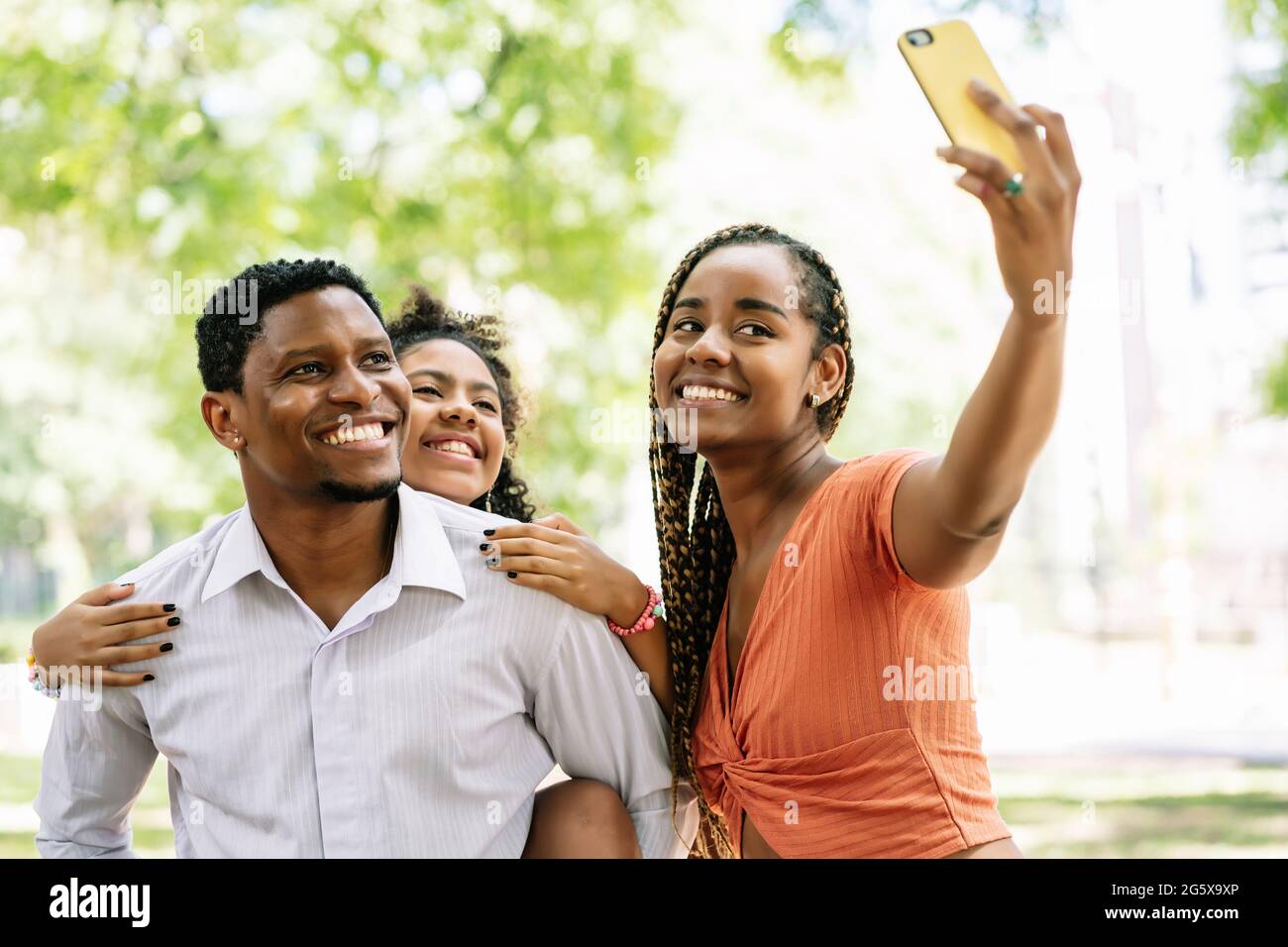 Famiglia che prende un selfie con un telefono cellulare al parco. Foto Stock