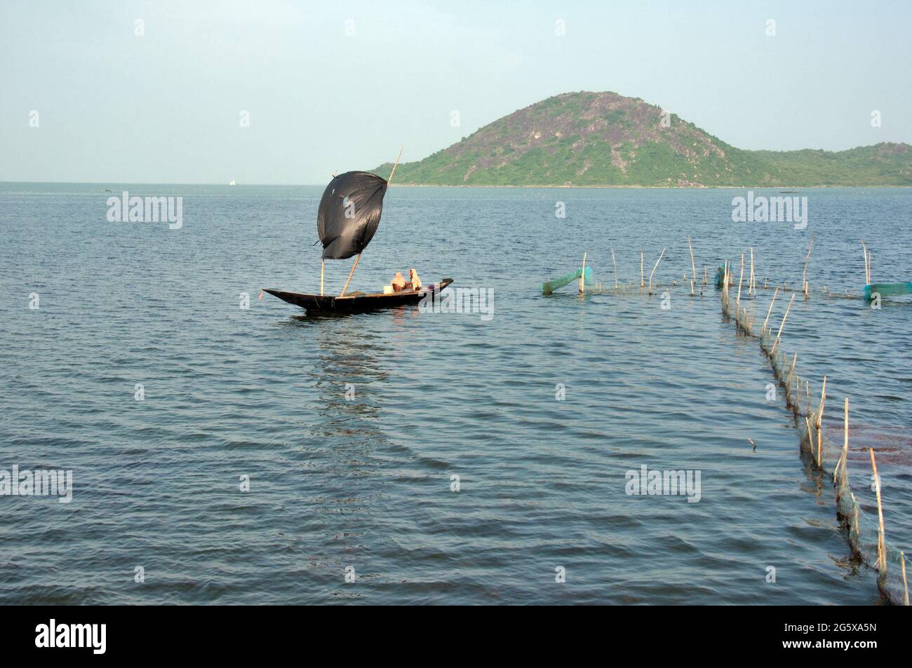 Foto del lago Chilka a Rambha, Odisha. I pescatori pescano nel lago con una barca a vela. Foto Stock