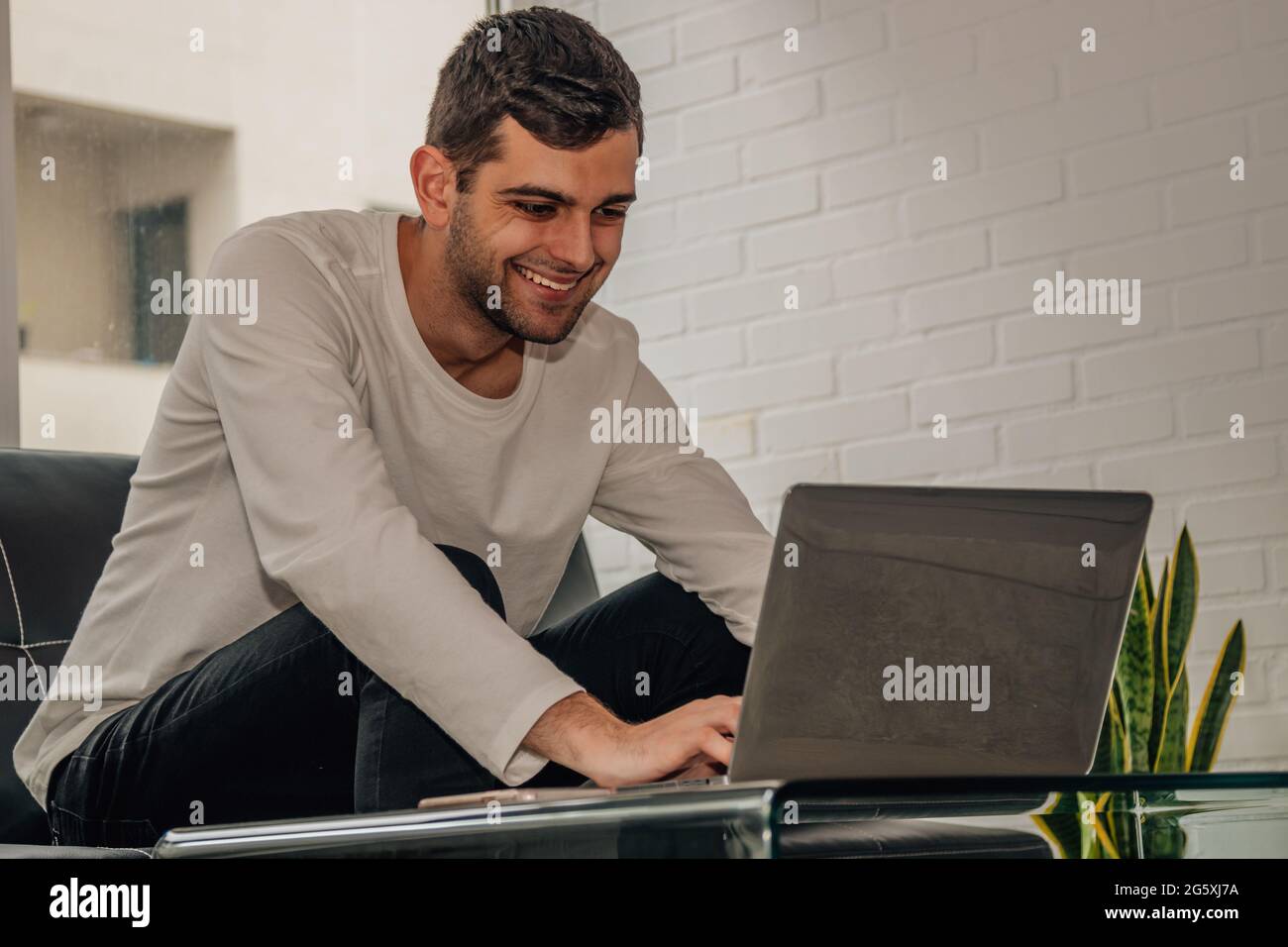 giovane uomo bearded che lavora con il laptop a casa Foto Stock