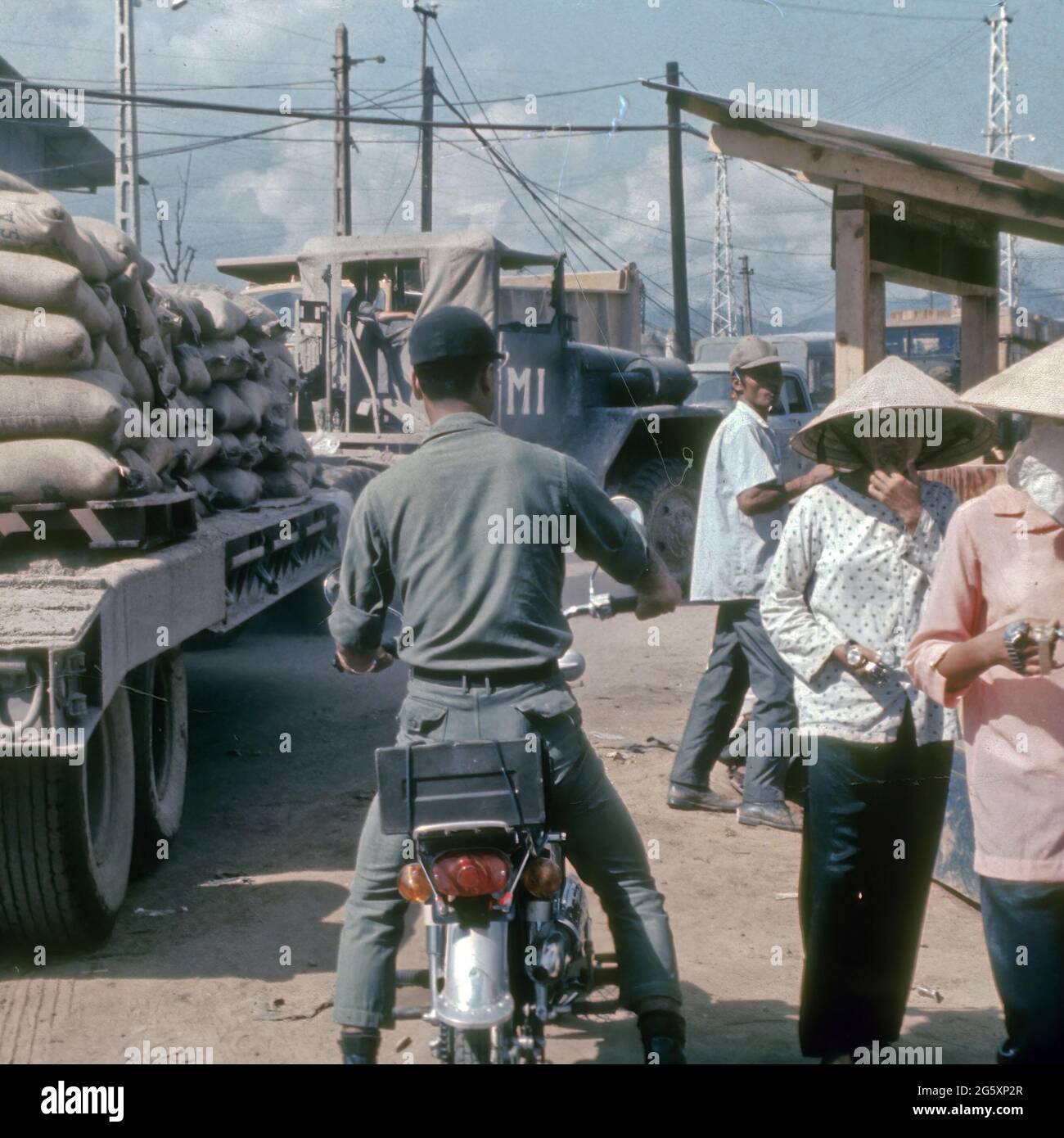 Autentica fotografia del 1968 di un uomo che cavalcava uno scooter con le donne locali a Danang durante la guerra del Vietnam. Foto Stock