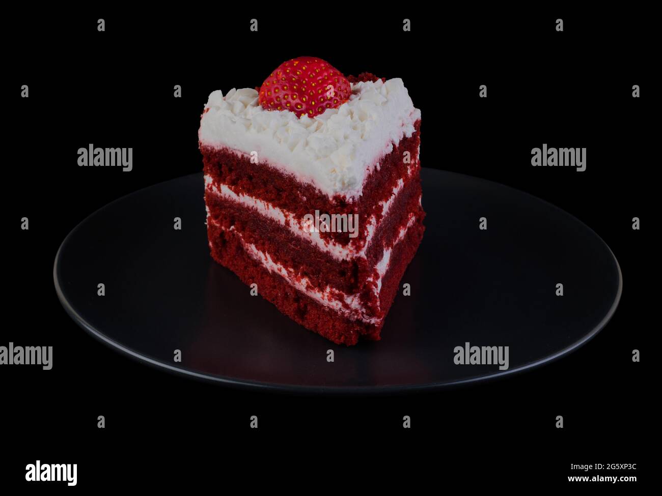 Pezzo di torta coperto di crema proteica e fragole su una piastra nera e fondo nero isolato Foto Stock