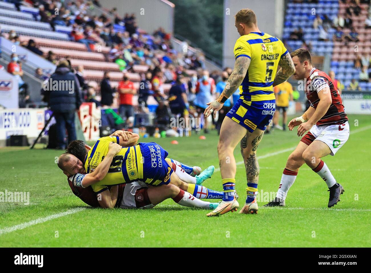 Jake Bibby (22) di Wigan Warriors Jake Mamo (18) di Warrington Wolves fuori gioco Foto Stock