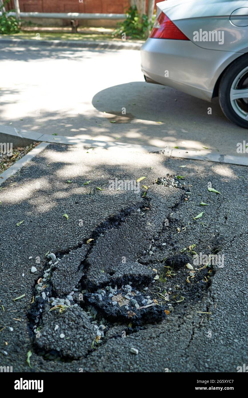 Nuovo, ma già gonfio e asfalto rotto Foto Stock