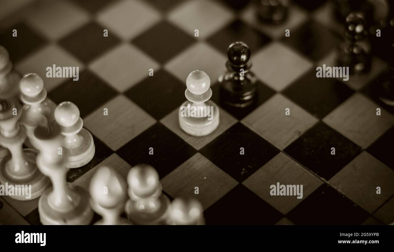 Due scacchi sono pedine: Nere e bianche. Pezzi di scacchi in legno sulla scacchiera, vista dall'alto. Gioco intellettuale - scacchi. Pezzi di scacchi sulla tavola. R Foto Stock