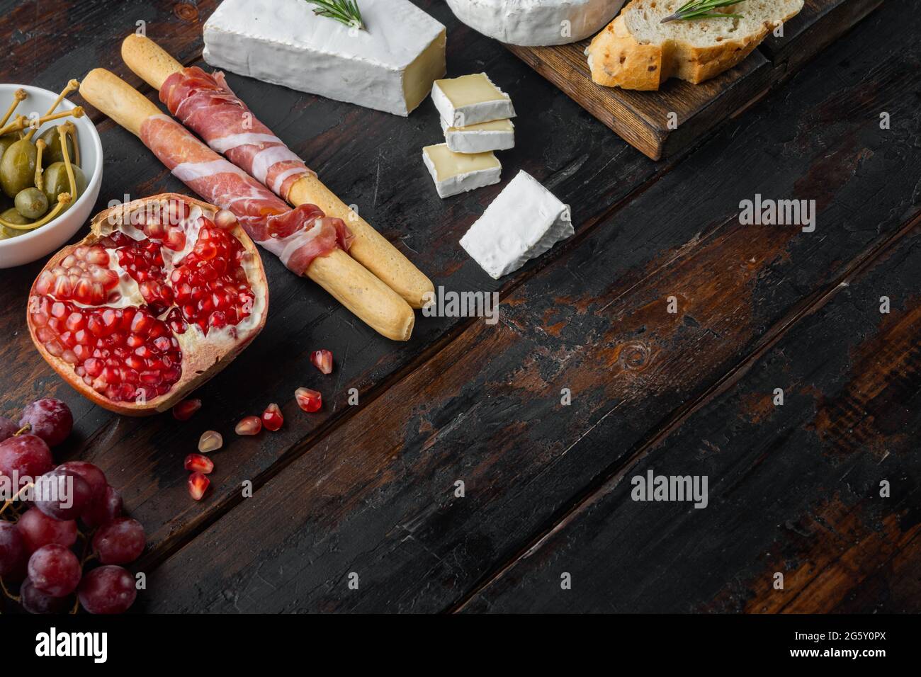 Tavola antipasti con diversi antipasti, su sfondo di legno scuro con spazio per la copia del testo Foto Stock
