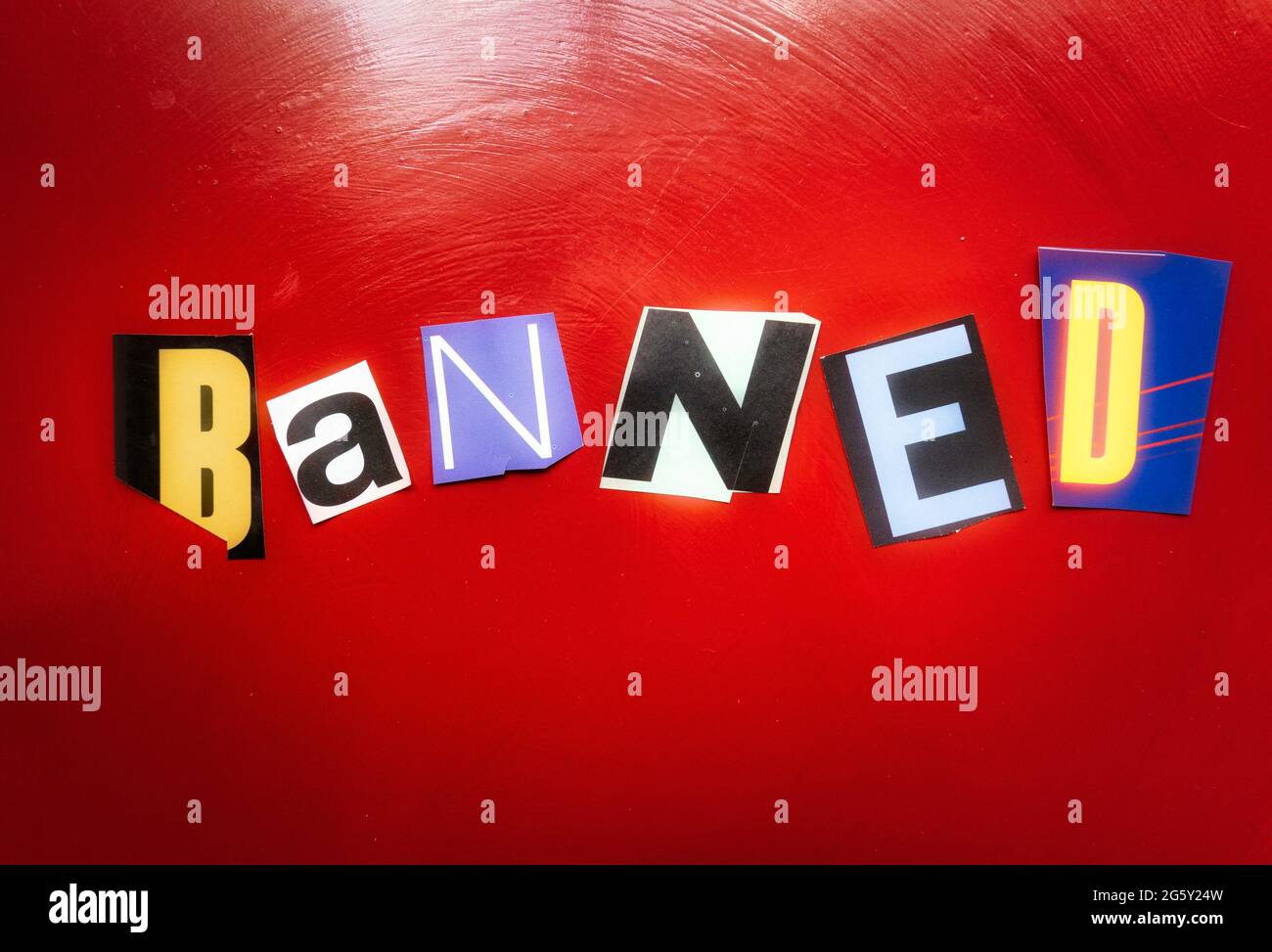 La parola 'banned' usando le lettere di carta tagliate nella tipografia dell'effetto di nota di riscatto Foto Stock