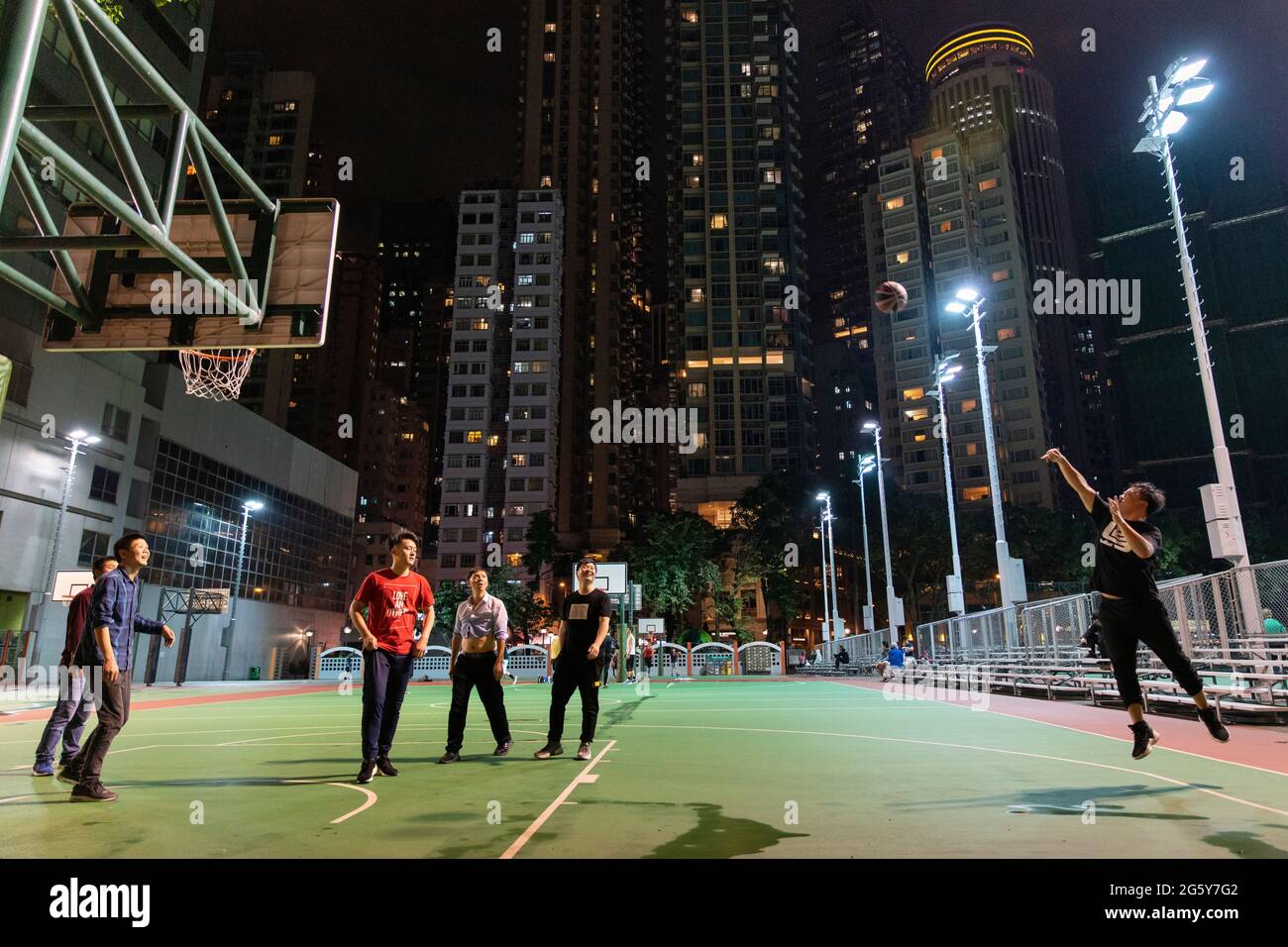 Pallacanestro che si gioca su un campo in centro città di notte a Hong Kong Foto Stock