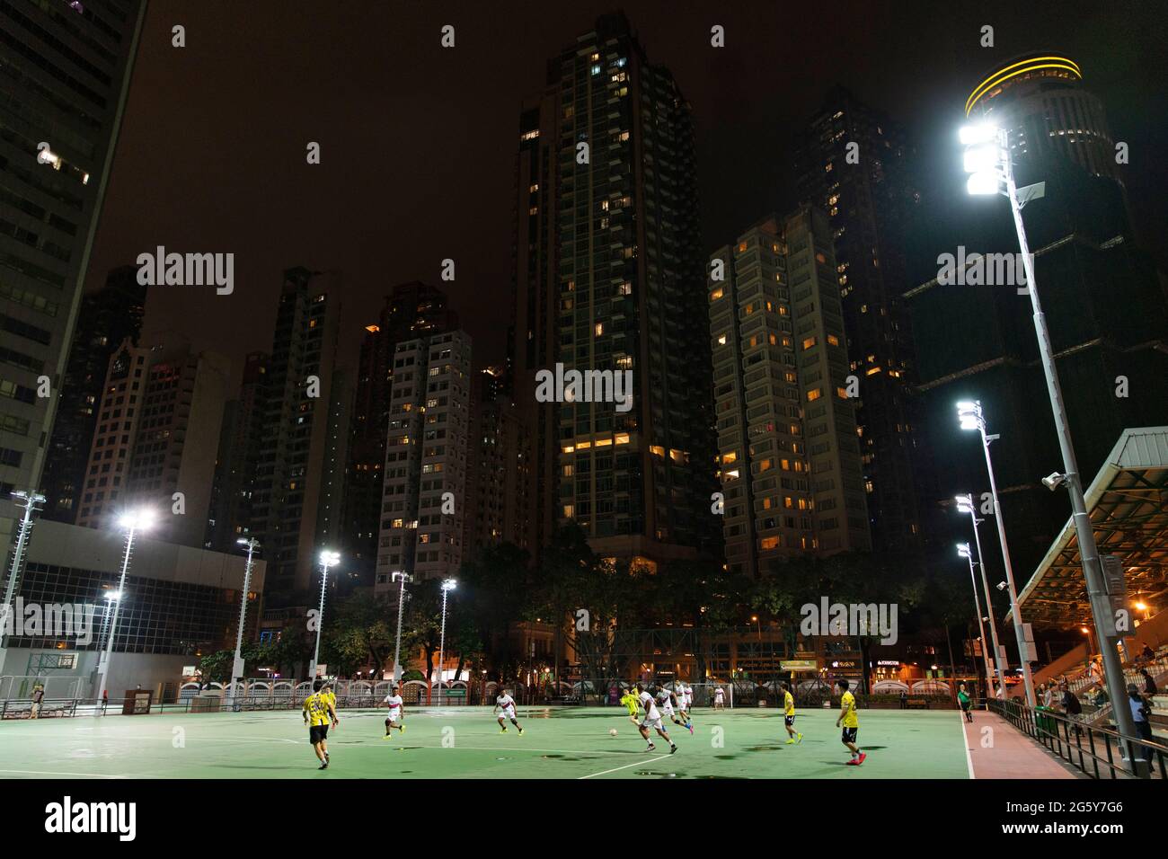 Calcio in corso su un campo in centro città di notte a Hong Kong Foto Stock