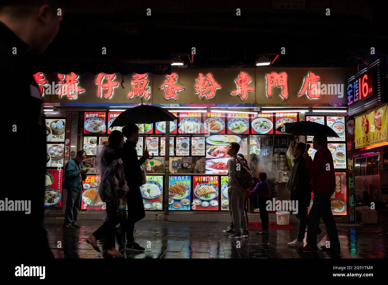Persone che camminano davanti a un ristorante cinese a Hong Kong, Cina Foto Stock