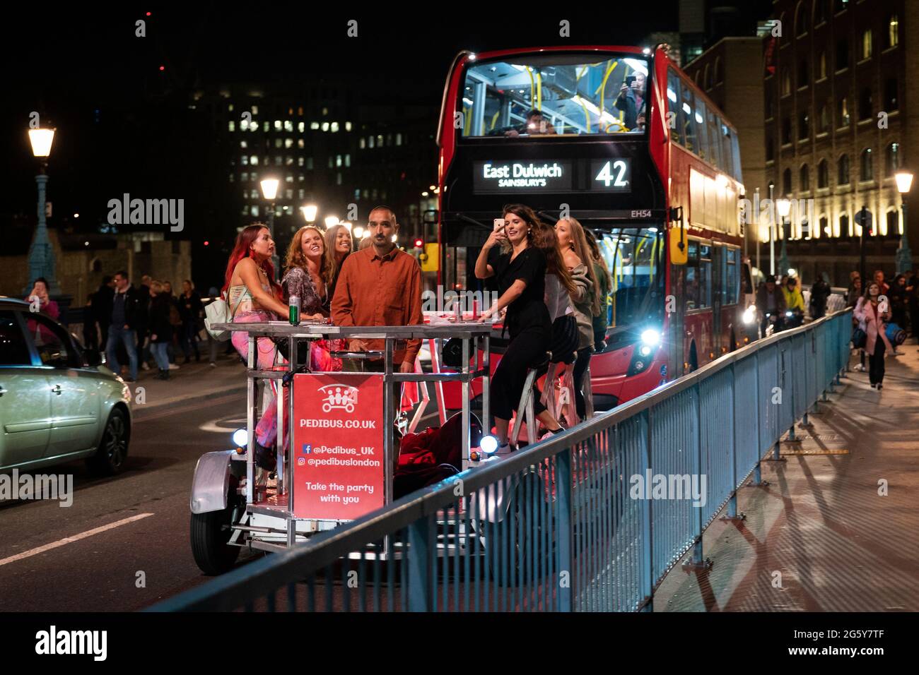 Un gruppo di donne in una festa in bicicletta di notte in una strada trafficata a Londra, Inghilterra Foto Stock