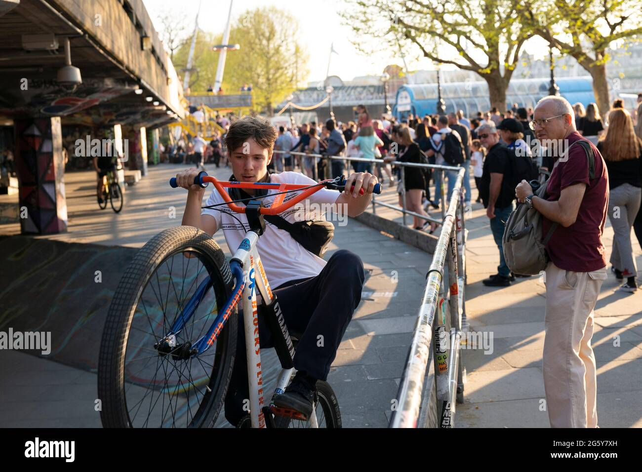 Ragazzi che fanno acrobazie sulle biciclette mentre i turisti guardano al Southbank Skate Space di Londra, Regno Unito Foto Stock