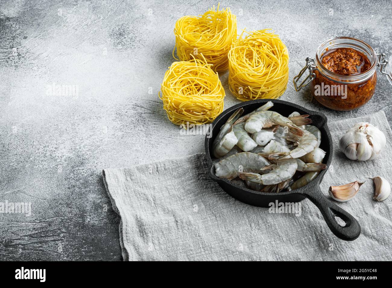 Pasta di gamberi al pesto ingredienti, su sfondo grigio in pietra, con spazio per la copia del testo Foto Stock