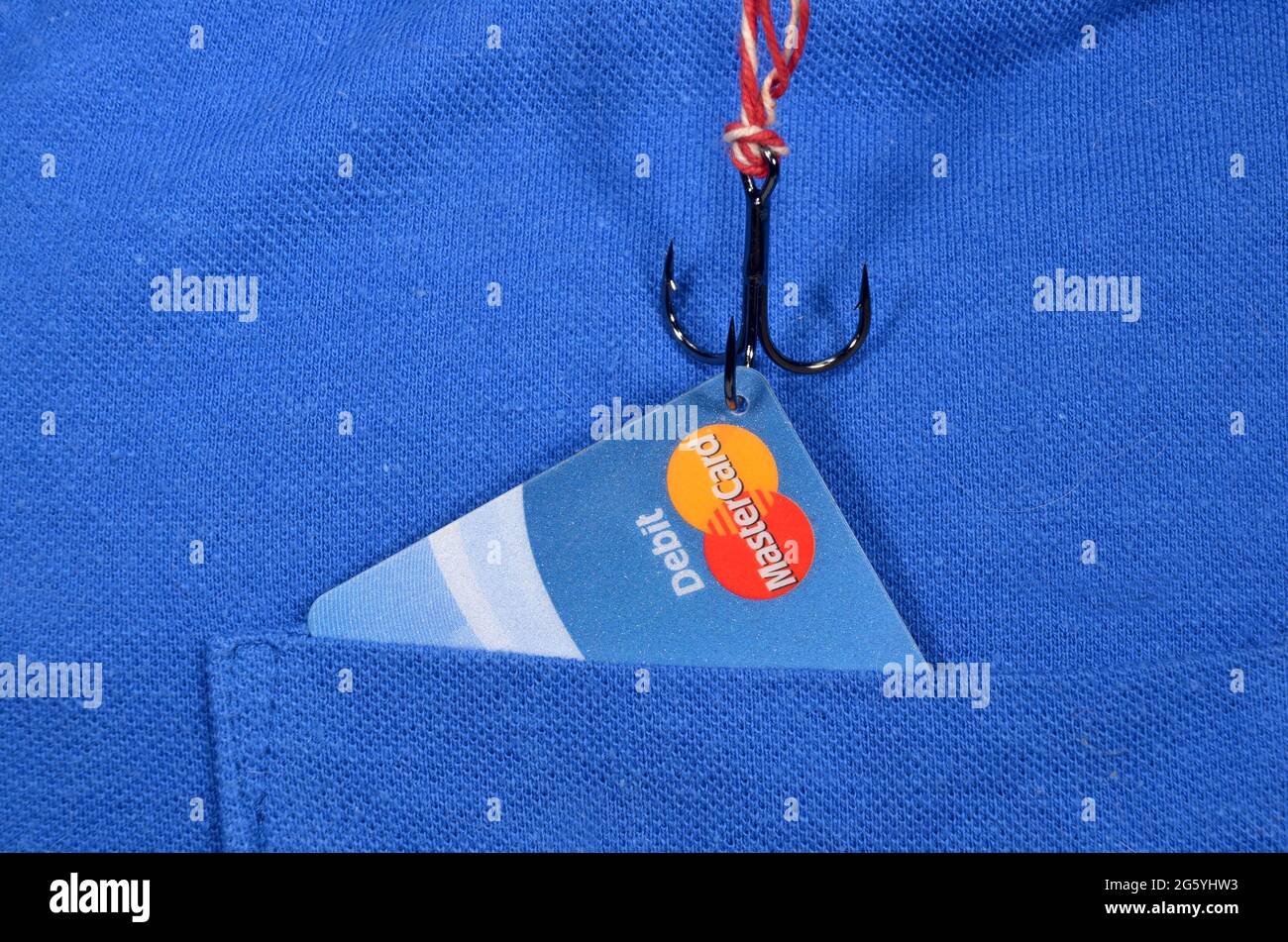 Sonderborg, Danimarca - 30 giugno 2021:il gancio da pesca prende una mastercard da una tasca di una T-shirt blu. Foto Stock