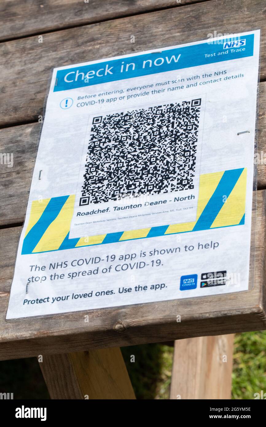 Stazione di servizio dell'autostrada. Cartello NHS Covid 19 Test and Trace sulla superficie di un tavolo da picnic, richiesta di codice QR, dettagli di contatto di clienti, clienti. Giugno Foto Stock