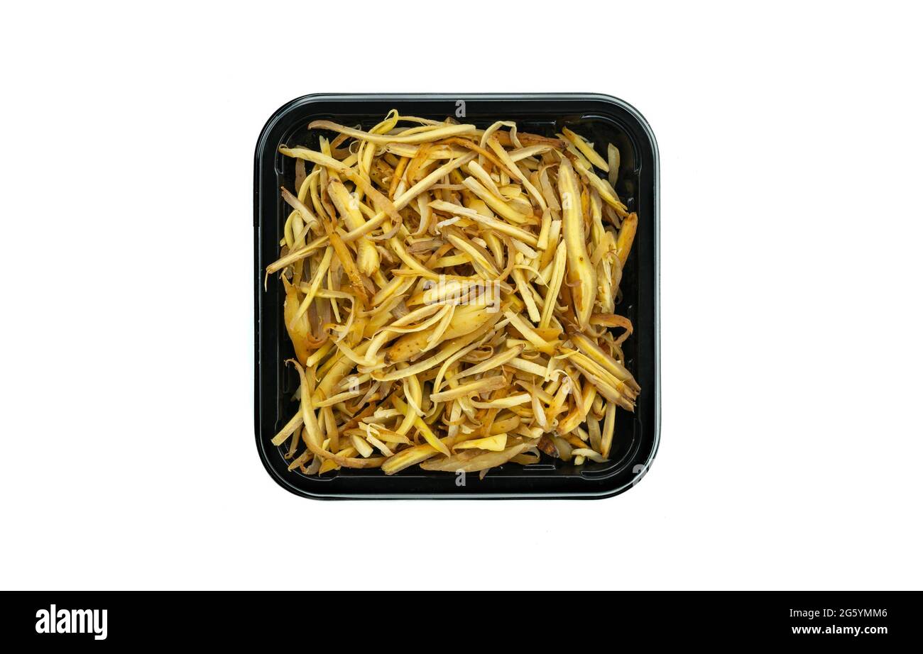 Vista dall'alto radice di dito tagliata in vassoio di plastica nero per la vendita in supermercato, radice di dito tagliata isolata in vassoio di plastica nero su sfondo bianco. Foto Stock