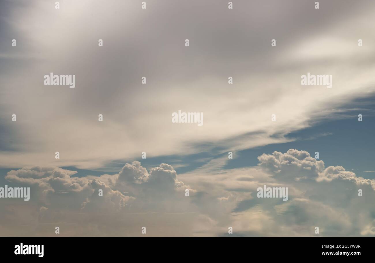 Il sole splende attraverso le nuvole nel cielo. La forma delle nuvole evoca immaginazione e creatività. Spazio di copia, fuoco selettivo. Foto Stock