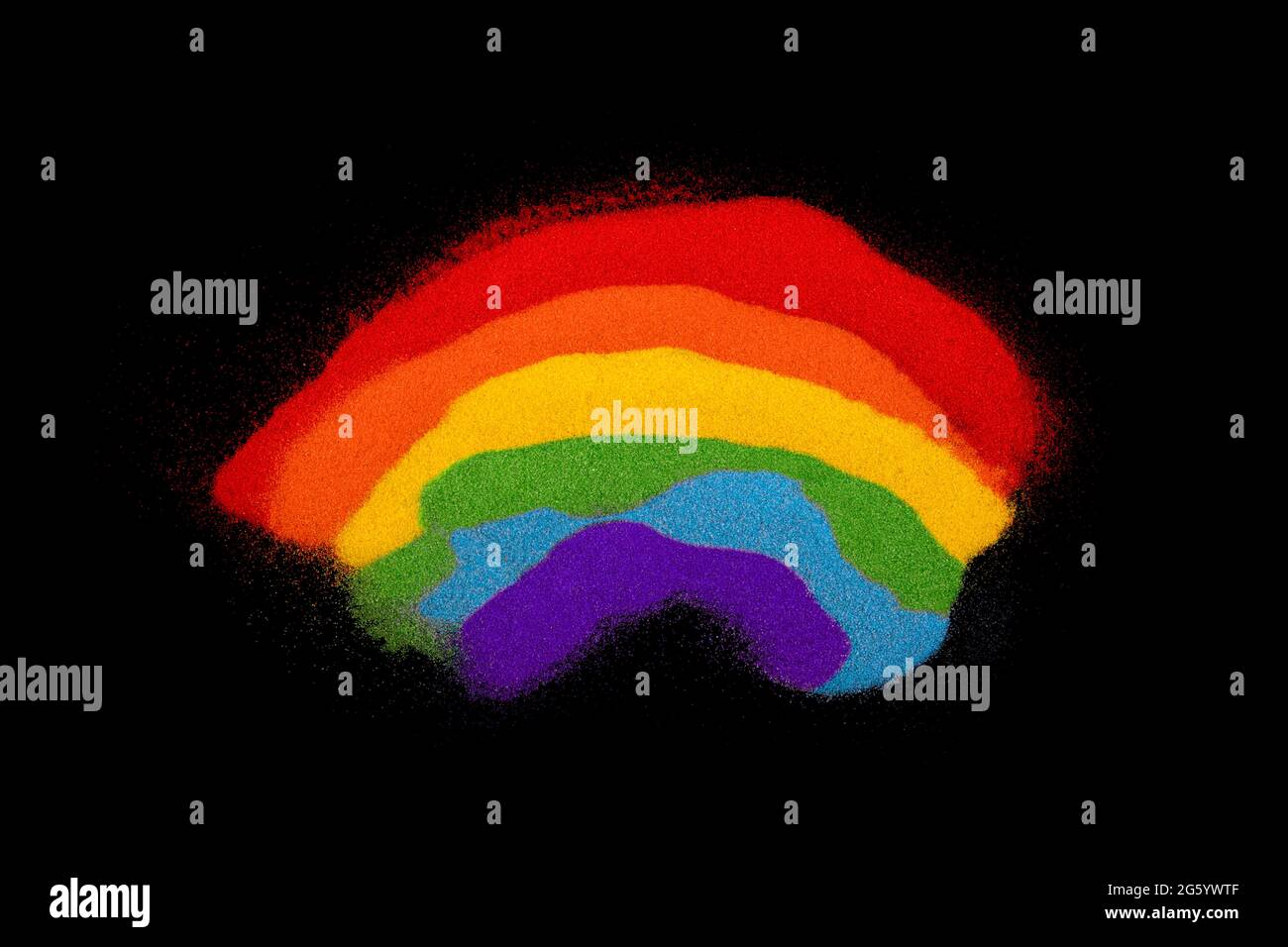 Arcobaleno colorato fatto di sabbie colorate su sfondo nero Foto Stock