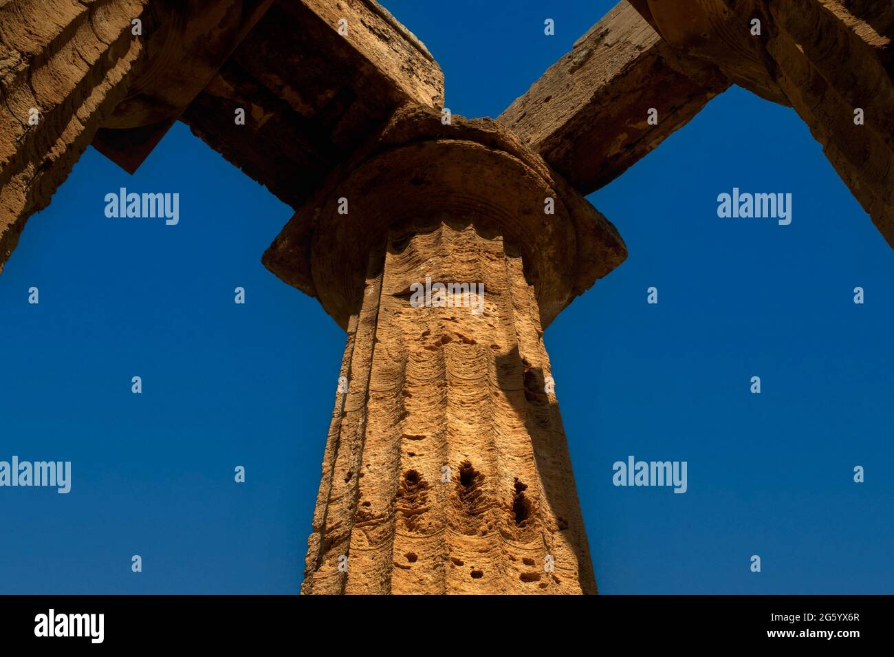 Colonna dorica snodata e scanalata e capitale all'angolo di un colonnato di un antico tempio greco nel Parco Archeologico di Selinunte in Sicilia, Italia. Il tempio, ora noto come Tempio e, è stato accuratamente ricostruito nel 1958 utilizzando materiali originali. Selinunte era in precedenza l'antica colonia greca di Selinunte o Selinous. Foto Stock