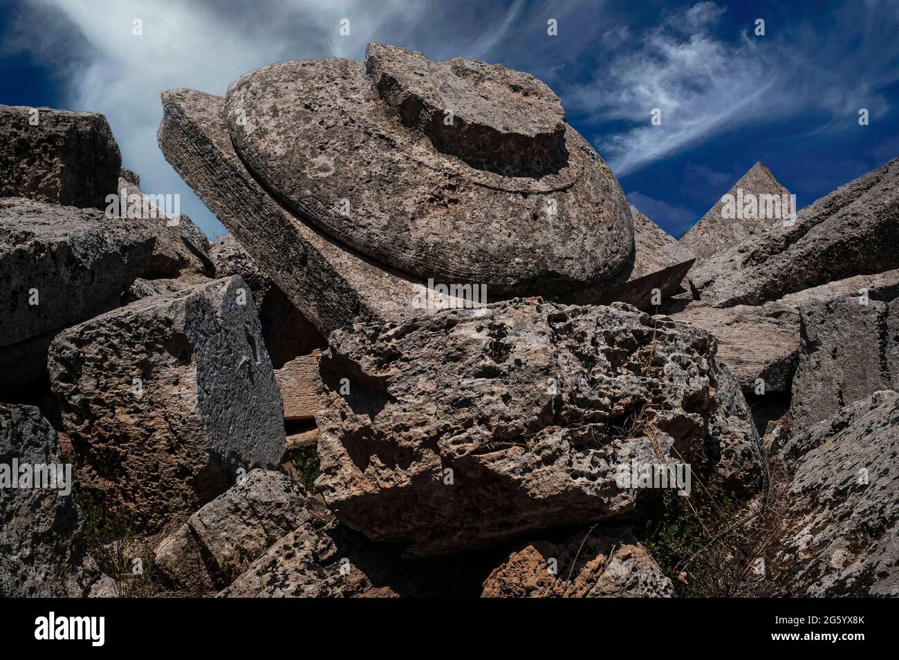 Capitale dorica invertita sulle rovine del crollato tempio greco antico dedicato ad Apollo o Zeus. Sul sito dell'antica città e del porto della capitale dorica invertita, sulle rovine dell'antico tempio greco crollato a Selinunte in Sicilia, Italia. La struttura, ora nota come Tempio G, fu fondata nel 530 a.C. e fu dedicata ad Apollo o Zeus. Selinunte era precedentemente la colonia greca di Selinunte o Selinous. Foto Stock
