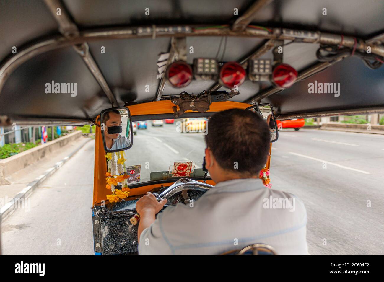 Un autista in tuk-tuk a Bangkok in Thailandia nel Sud-Est asiatico. Foto Stock