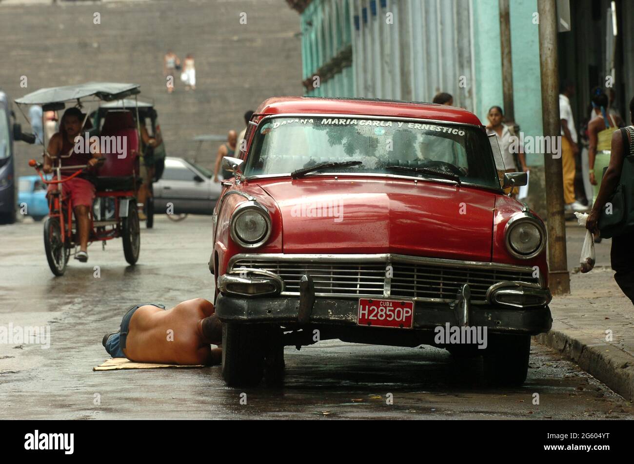 Uomo che ripara la sua vecchia auto per le strade di l'Avana, Cuba maggio 2006. Riparazioni riparazioni riparazione manutenzione uomini cubani classica auto d'epoca riparazione guasti Foto Stock