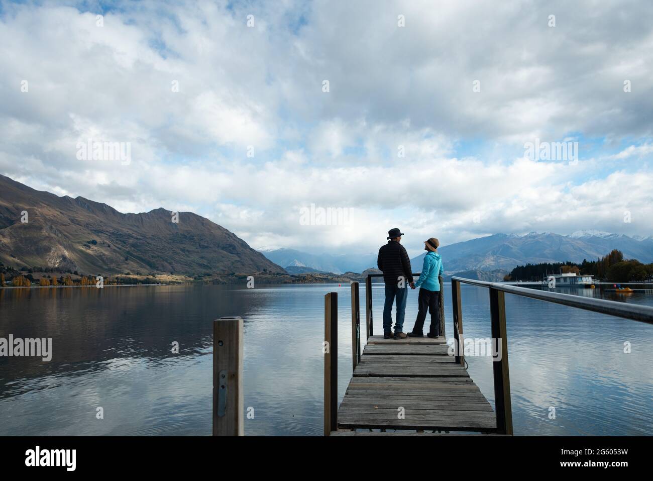 Coppia che si trova sul molo del lago Wanaka, guardandosi l'un l'altro. Regione di Otago, Isola del Sud Foto Stock