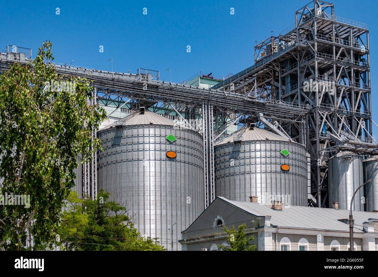 Silos per immagazzinare cemento usato nella costruzione. Fabbrica di cemento. Silos a torre in metallo dell'impianto industriale. Foto Stock