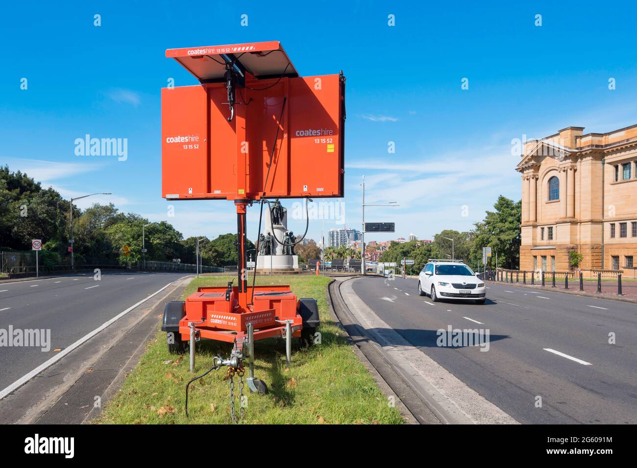 Un pannello di messaggio variabile alimentato a energia solare o un cartello di messaggio sulla striscia di terreno erboso o una strada principale della città di Sydney in Australia Foto Stock