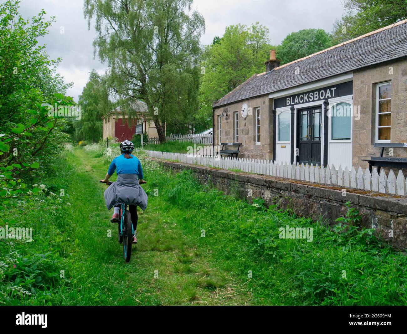 Ragazza in bicicletta sulla linea ferroviaria in disuso, Grampian Foto Stock