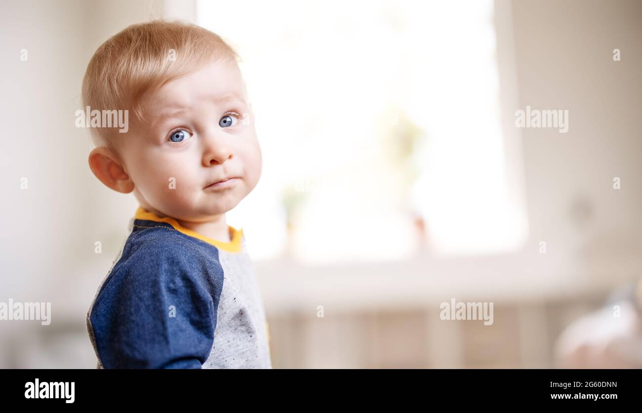 Ragazzo carino in piedi nella stanza bianca Foto Stock