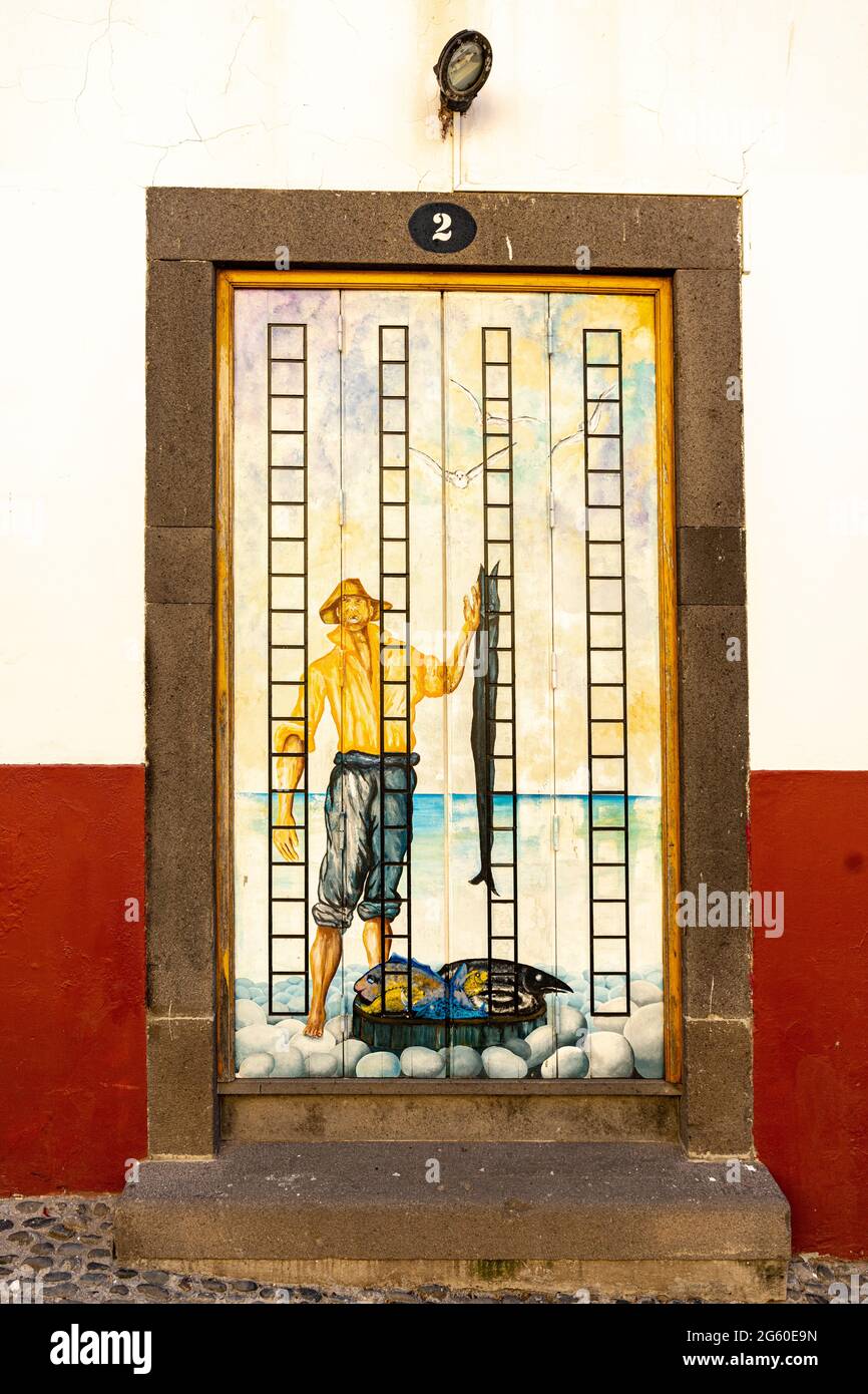 Affresco dipinto sulle porte nella stretta strada acciottolata Rua de Santa Maria nel centro storico di Funchal, isola di Madeira, Portogallo Foto Stock