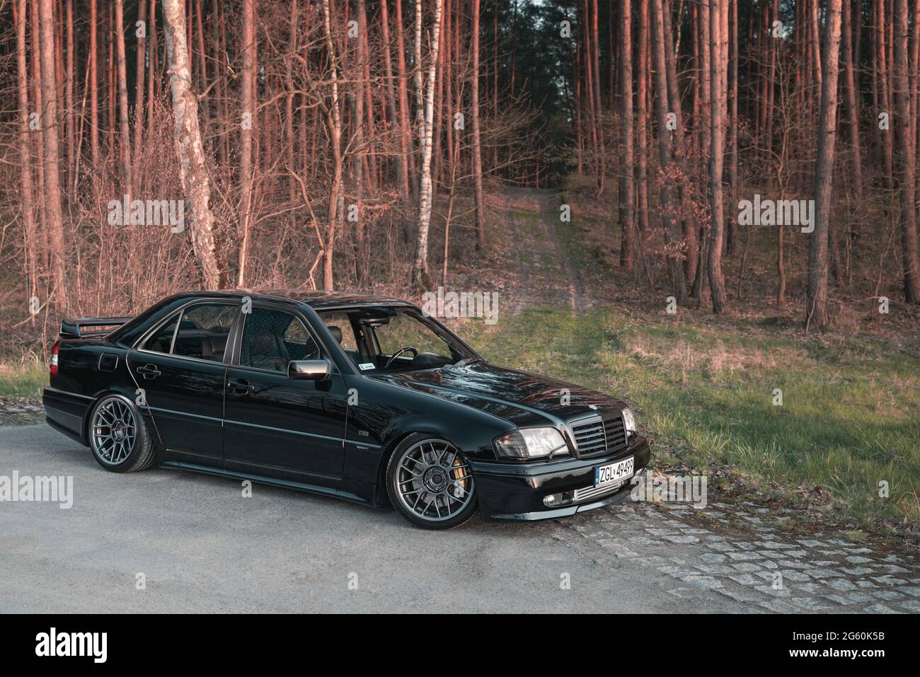 Goleniow, Polonia - 20 aprile 2021: Vecchia Mercedes Benz classe C (modello  W202) sintonizzata nera vicino alla foresta. Icona berlina compatta e di  lusso degli anni '90. Vista laterale Foto stock - Alamy