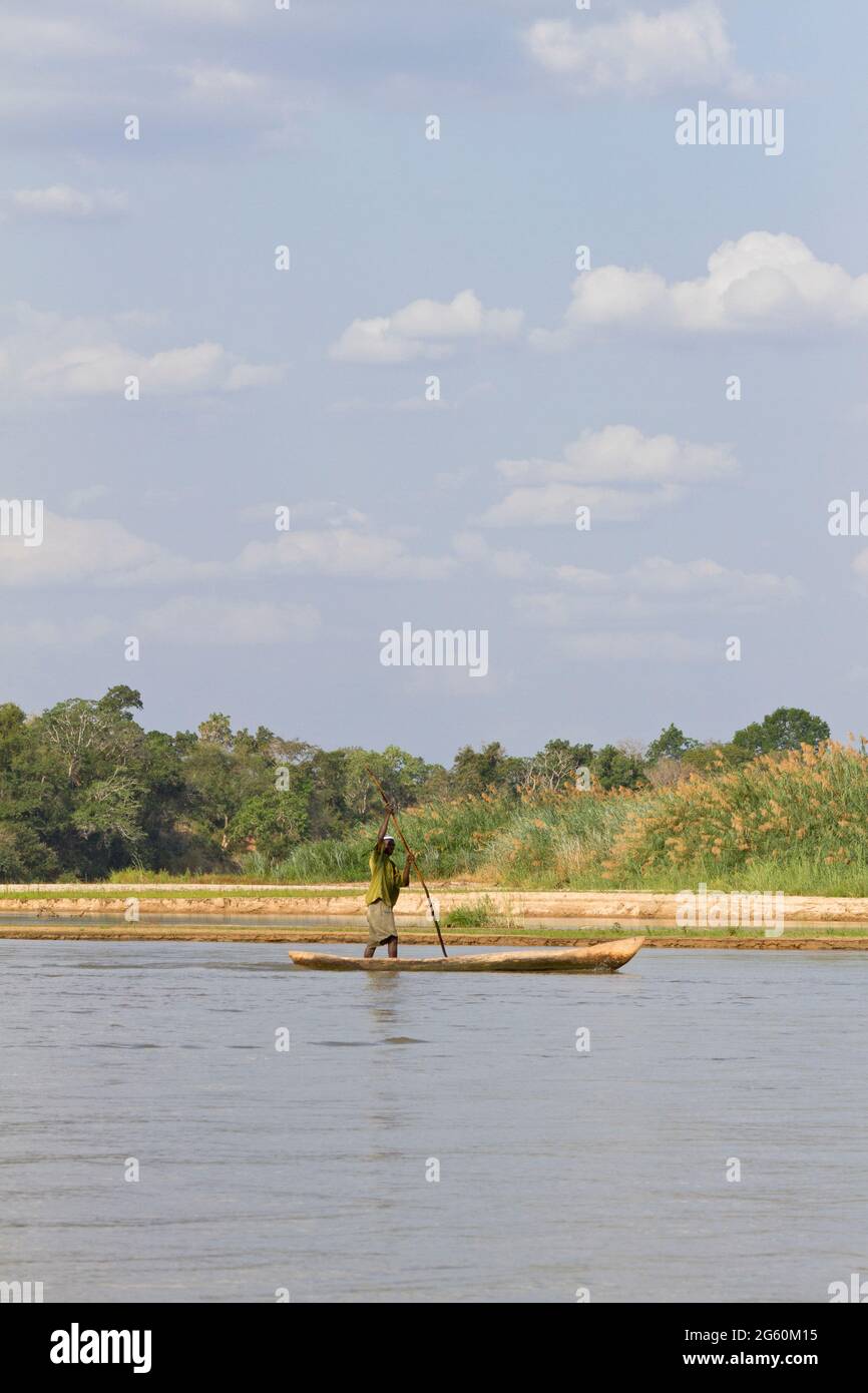 Un uomo del posto regna lungo il fiume Rufiji in una canoa. Foto Stock