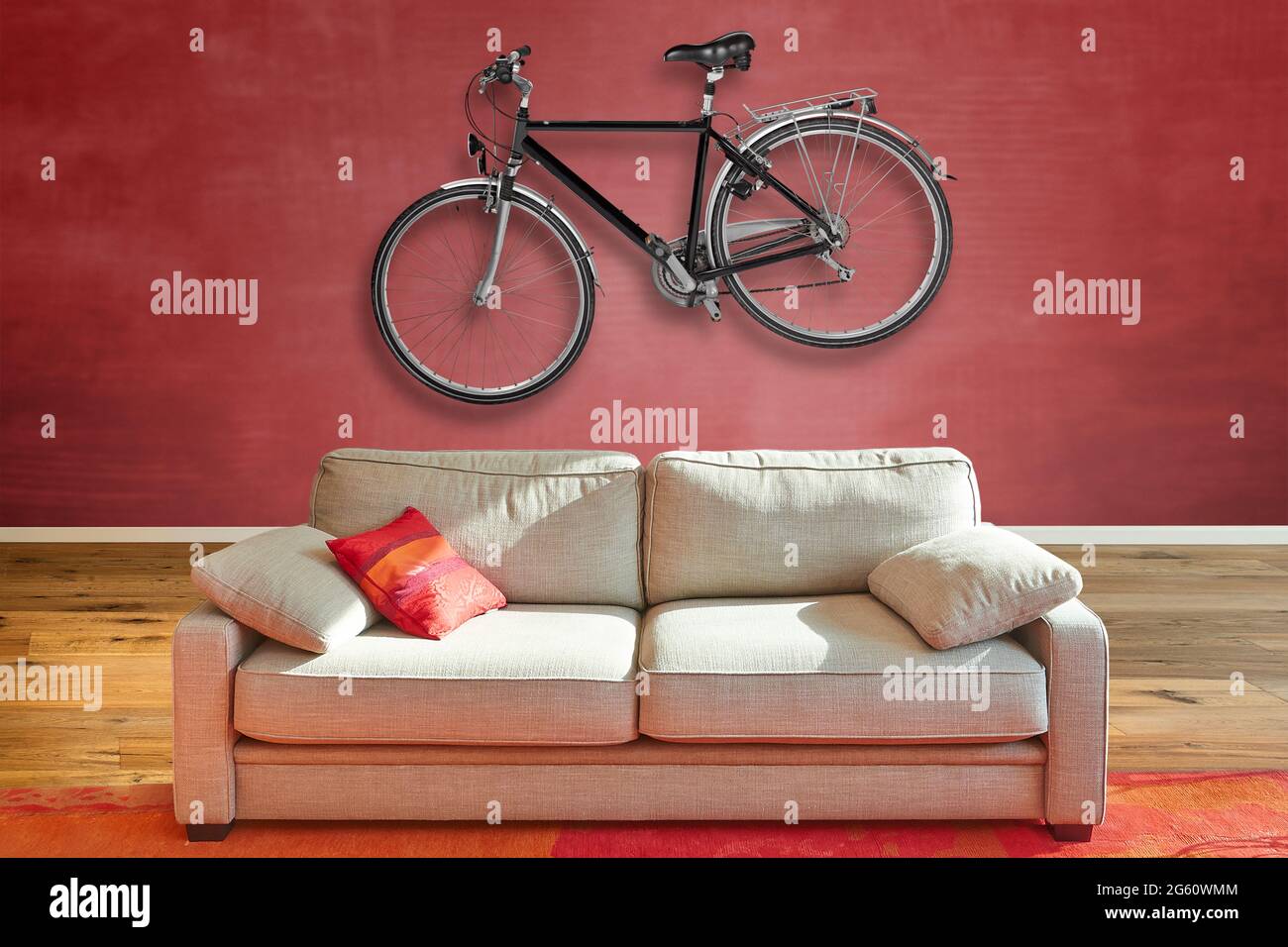 Elegante divano classico di fronte in un lussuoso appartamento con una bici da strada Hanging a parete. Foto Stock
