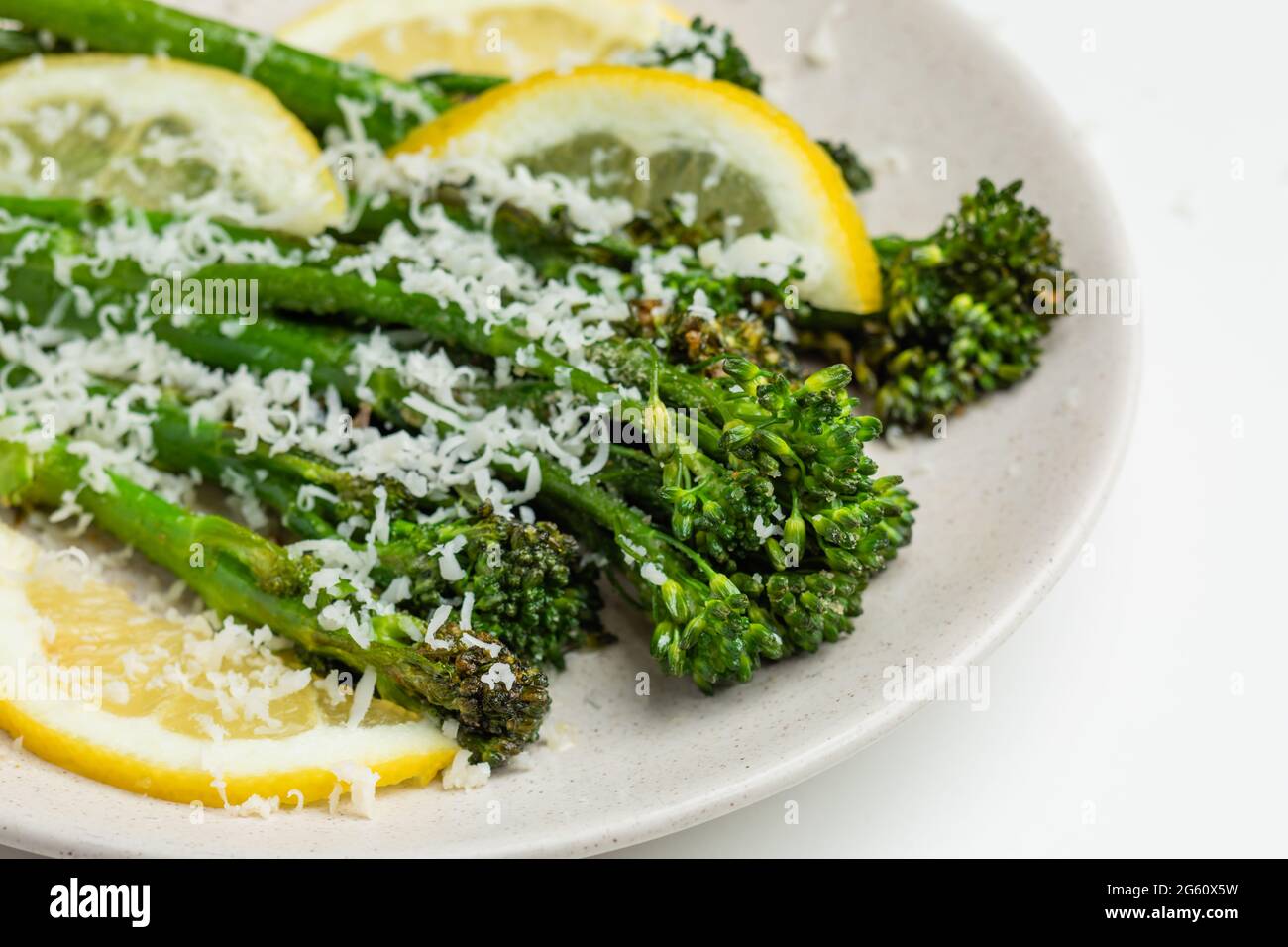 Broccolini freschi cotti con formaggio grattugiato sul piatto Foto Stock