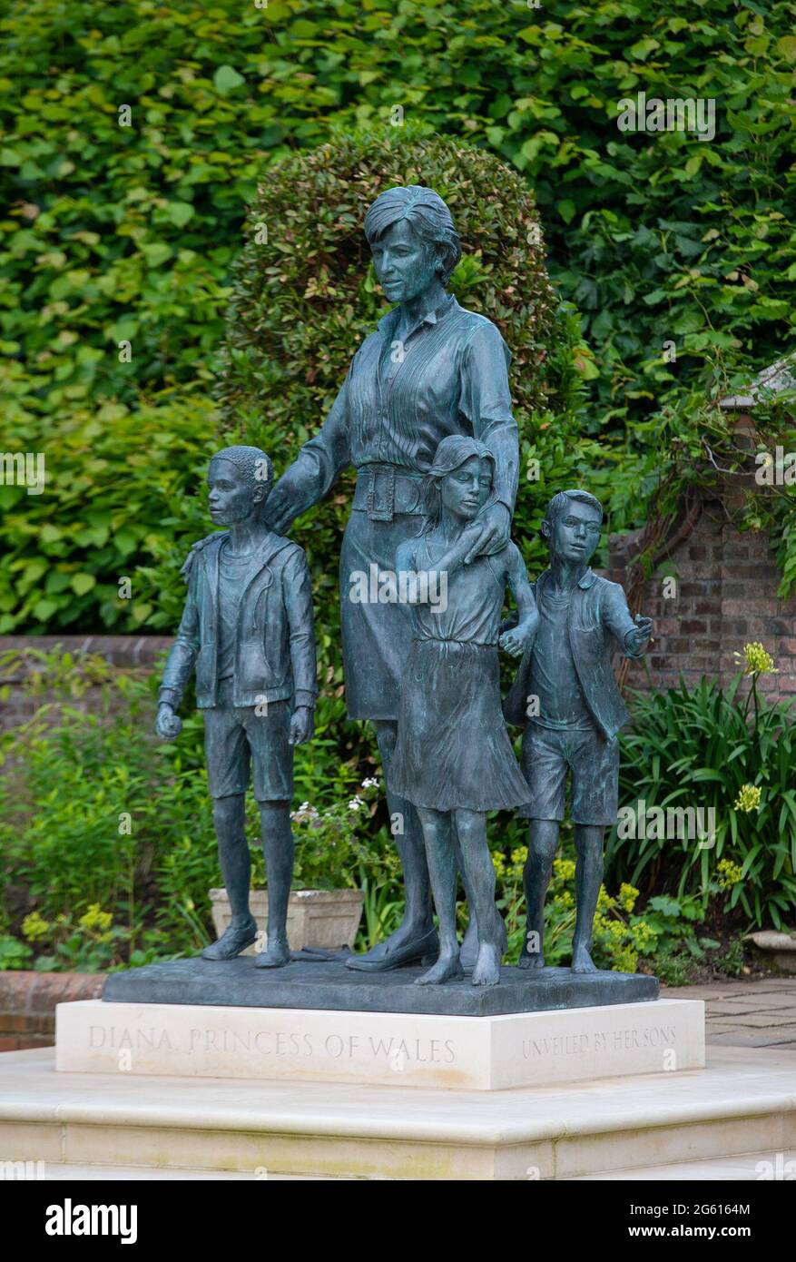 La statua di Diana, Principessa del Galles, dell'artista Ian Rank-Broadley, nel Giardino Sunken a Kensington Palace, Londra. La statua in bronzo raffigura la principessa circondata da tre bambini per rappresentare l'universalità e l'impatto generazionale del suo lavoro. I suoi capelli corti corti, lo stile di vestito e il ritratto sono basati sul periodo finale della sua vita. Sotto la statua è inciso uno zoccolo con il suo nome e la data della scoperta, e di fronte è una pietra di pavimentazione incisa con un estratto ispirato alla misura DI un poema uomo. Data immagine: Giovedì 1 luglio 2021. Foto Stock