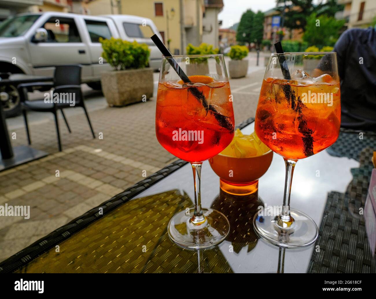 Due bicchieri di cocktail estivo sul tavolo davanti alle patate fritte e alla strada della città. Aperitivo Foto Stock