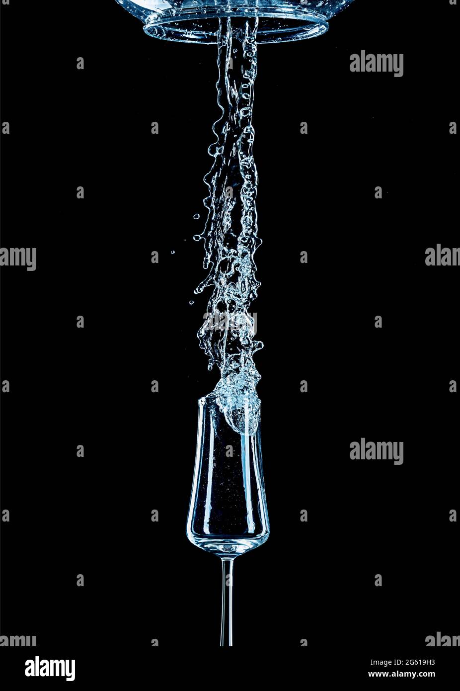 Spruzzi d'acqua con vetro rovesciato e sfondo nero. Foto Stock