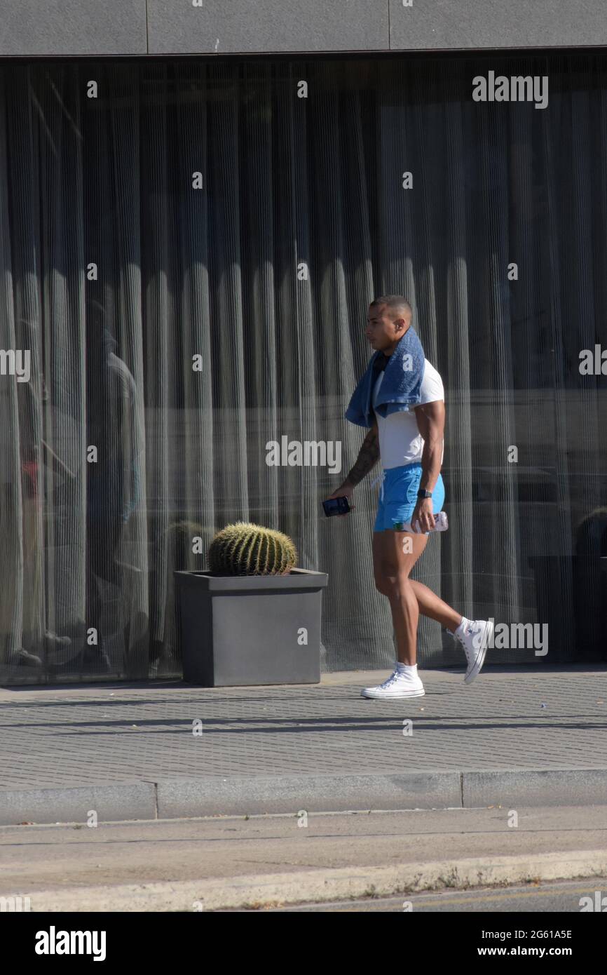 Giovane uomo mulatto che indossa abbigliamento sportivo camminando in una strada. Foto Stock