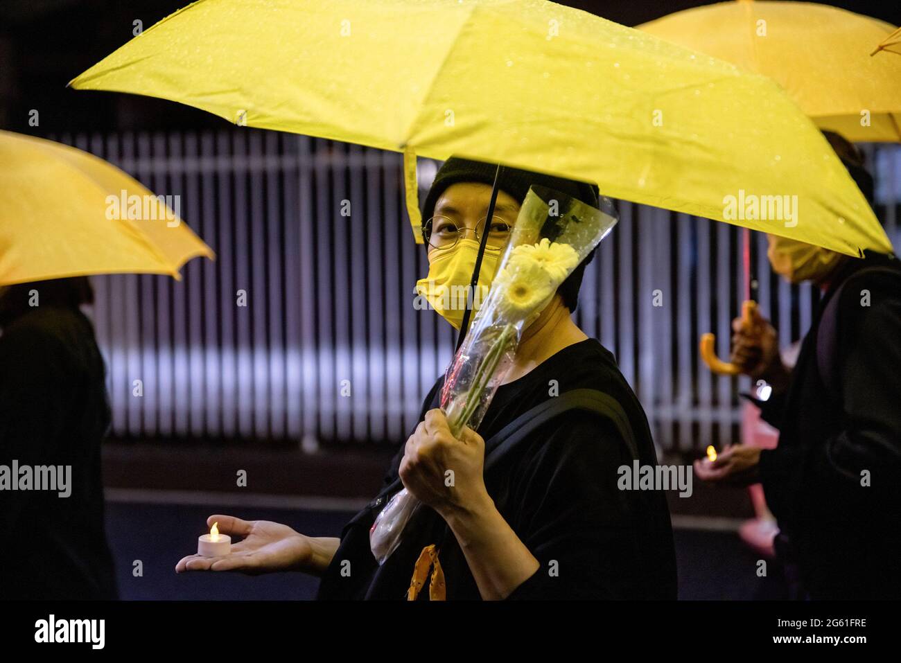Tokyo, Giappone. 01 luglio 2021. Un protestore che tiene fiori e un ombrello, durante la manifestazione.1 luglio segna il centesimo anniversario della fondazione del CCP (Partito comunista cinese) e il 24° anniversario della consegna di Hong Kong in Cina. I sostenitori del partito comunista cinese si sono presi in strada per festeggiare mentre i manifestanti favorevoli alla democrazia di Hong Kong hanno anche fatto marcia attraverso la capitale per esprimere le loro posizioni di politica. Credit: SOPA Images Limited/Alamy Live News Foto Stock